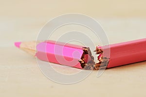 Close-up of broken pink colored pencil - Concept of violence against women