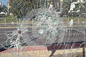 Close up of broken safety glass with many cracks at a bus stop on a city street