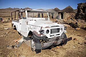 Close-up broken white car in abandoned village.