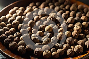 Close-up of brown allspice jamaica pepper grains in the bright sunlight. Texture of whole dried pimento berries. Concepts of