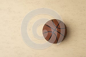 Close up of brown basketball ball isolated on beige background. Sport team concept. Top view, space for your text