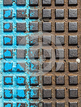 Close - up of a brown and blue manhole cover