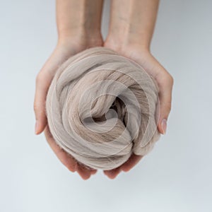Close-up of brown merino wool ball in hands