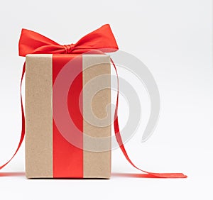 Close-up brown paper gift box red bow ribbon white background. concept for happy love gift