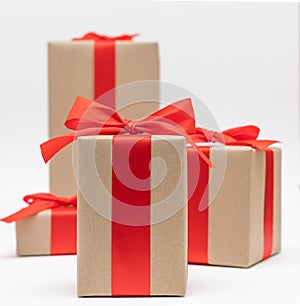 Close-up brown paper gift box red bow ribbon white background. concept for happy love gift