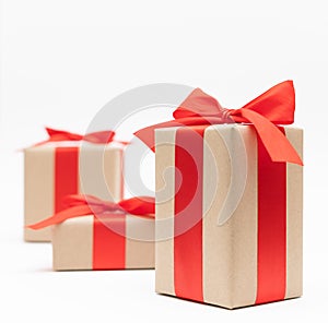 Close-up brown paper gift box red bow ribbon white background. concept for happy love gift