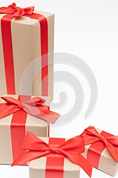 Close-up brown paper gift box red bow ribbon white background. concept for happy love gift