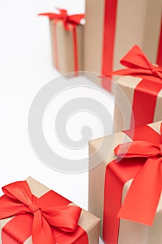 Close-up brown paper gift box red bow ribbon white background. concept for happy love gift