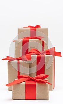 Close-up brown paper gift box red bow ribbon white background. concept for happy love gift