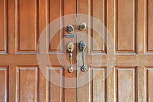 Close up brown wooden door with key lock and handle