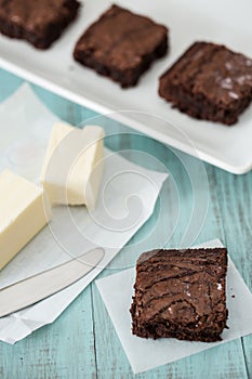 Close Up of Brownies Set On a Plate and a Stick of Butter