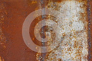 Close up of a brownish rusted welded sheet metal surface with yellowish and orange hue