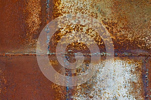 Close up of a brownish rusted welded sheet metal surface with yellowish and orange hue