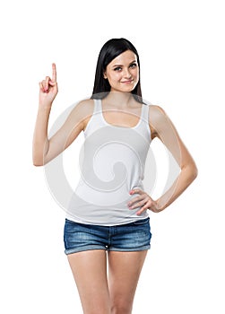 Close up of a brunette lady in a tank top and denims who points her finger up. A concept of a new idea.