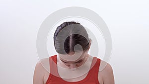 Close up of a brunette woman making circular movements a head. Doing spasm-removing exercise for neck muscles.