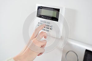 Close up on brunette woman's hand entering code on keypad