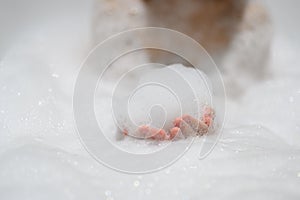 Close-up bubble foam on boy hands surrounded by soap suds when taking a bath in bathtub. Funny, healthcare lifestyle and hygiene