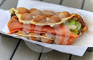 Close up of a bubblewrap or bubble waffle smoked salmon sandwich in London, UK