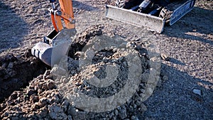 Close up bucket of excavator excavate earth at construction site.