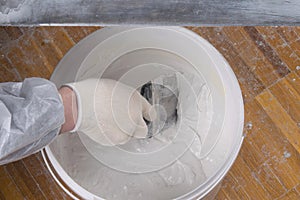 Close-up of a bucket, with finishing putty for concrete walls