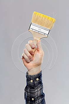 Close up of builder`s hand holding paint brush