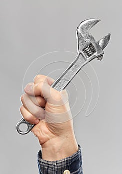 Close up of builder`s hand holding wrench