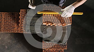 Close-up of Builder using leveller for brickwork. Stock footage. Professional work of builders during brick laying