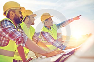 Close up of builders with blueprint on car hood