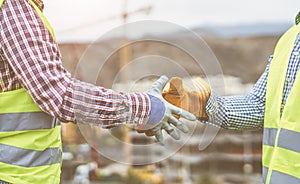 Close up builders hands making a deal - Workers on construction site reaching an agreement