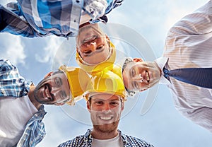 Close up of builders wearing hardhats in circle