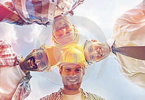 Close up of builders wearing hardhats in circle