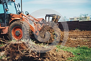 close up of bulldozer moving earth and leveling garden