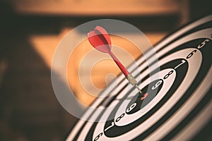 Close-up the bullseye or bulls eye target or dart board has dart arrow throw hitting the center