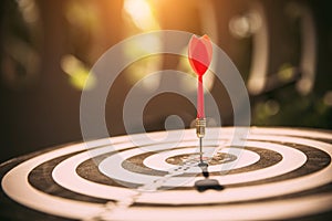 Close-up the bullseye or bulls eye target or dart board has dart arrow throw hitting the center