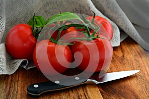 Close up of a bunch of red tomatoes, ready to be cut for salads.