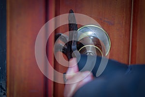 Close up of a burglar with crowbar trying break the door to enter the house