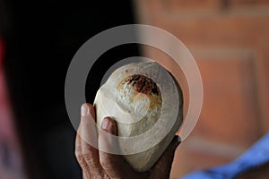 Close-up of a Burned coconut in a human hand.