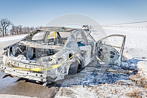 Close up of a burned out car with caution tape