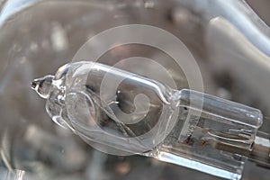 Close-up of a burned out malfunctioning incandescent light bulb with broken wolfram filament inside a glass lamp