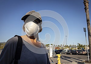 Close up of burnette woman  wearing face mask with baseball cap in store parking lot photo