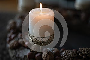 Close-up of a burning candle in a candlestick with ornaments on an Advent wreath