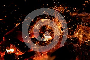 Close up of burning coals with sparks flying in the air