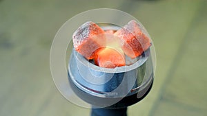 Close-up of burning embers on hookah. Media. Square red coals ignite when hookah is inflated. Red coals burn on hookah