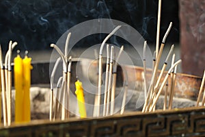 Close up burning incense sticks and smoke from incense burning.