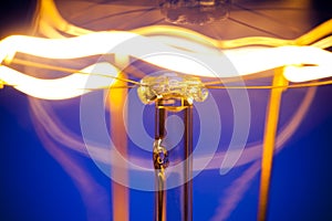 Close-up of burning light bulb with tungsten filament in center