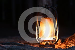 Close up burning old oil lamp in forest at night. Night scenery of a nightmare scene.