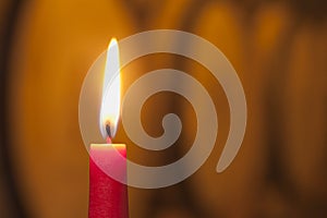 Close-up of a burning red candle in a wine cellar