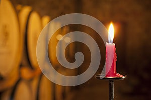 Close-up of a burning red candle in a wine cellar