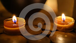 Close-up of burning tealight candle on table in home