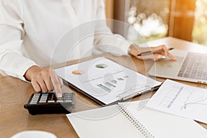 Close up business hands using calculator for calculating financial data report of company